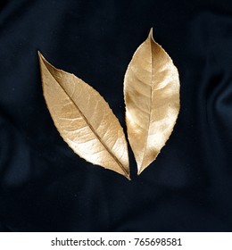 Gold Leaf Isolated On Black Silk. Luxury Background.