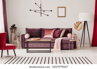 Gold Leaf On Copper Table In Sophisticated Living Room Interior With Striped Carpet And Violet Sofa