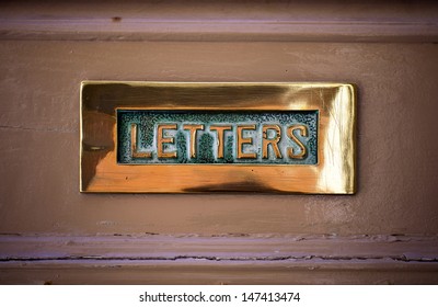 Gold Letterbox On Old Brown Door