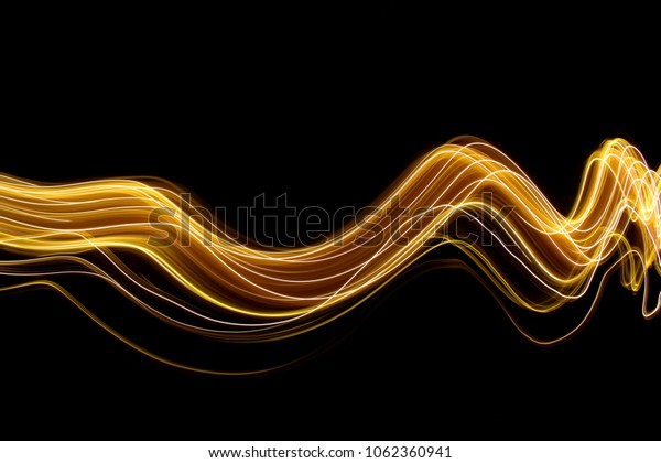 Gold light painting\
photography, long exposure photo of metallic fairy lights against a\
black background