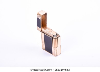 A Gold Lighter On A White Backdrop