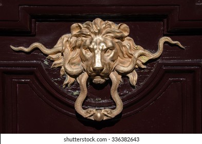 Gold lion door knocker on building in central Paris