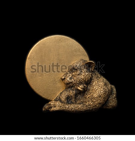 Gold lion. Handmade bronze sculpture miniature bas relief medal badge on black background.