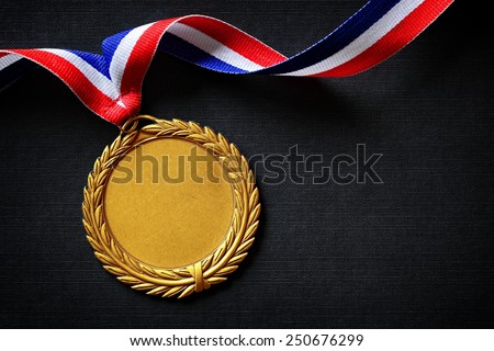 Gold medal on black with blank face for text, concept for winning or success