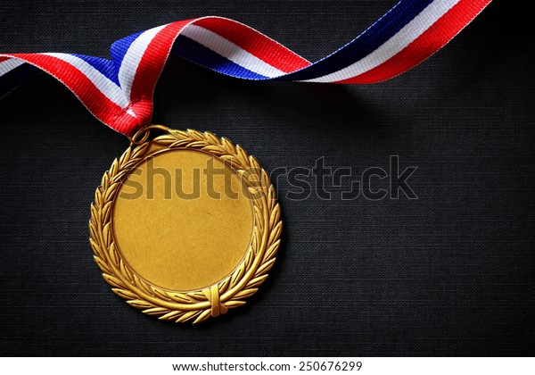 Gold medal on black with blank face for text,\
concept for winning or\
success