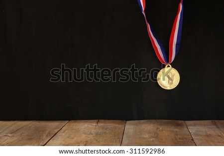 Gold medal over textured black background with room for text, winning and success concept