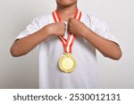 Gold Medal. The winner is holding a gold medal on his chest. Sports trophy for first place on a white background