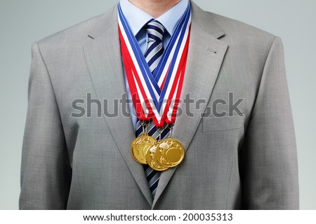 Gold medals hanging around a businessman neck concept for success and winning in business