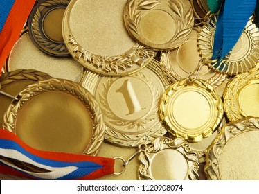 A Lot Of Gold Medals With Ribbons 