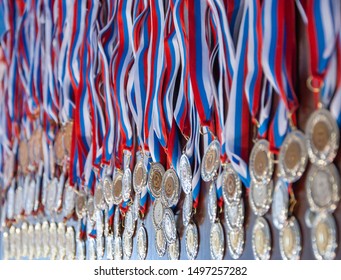 A Lot Of Gold Medals With Ribbons