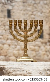 A Gold Menorah With A Background Of The Walls Of Jerusalem