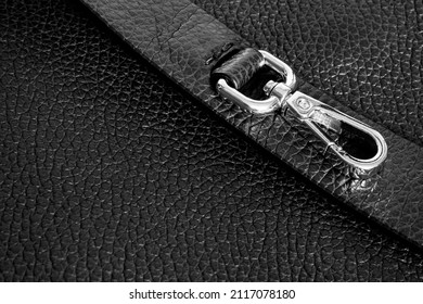 Gold Metal Carabiner With A Ring On The Strap Of A Black Bag