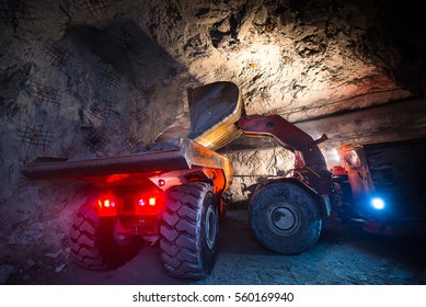 Gold mining underground. Loading truck with golden ore in the tunnel.