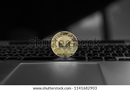 Gold Monero coin on a laptop keyboard. Exchange, bussiness, commercial. Profit from mining crypt currencies. Miner with ethereum coin.