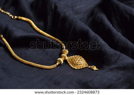 Gold Necklace display with satin black cloth, Indian Traditional Gold Necklace in black velvet background, Authentic Traditional Indian Jewellery Necklace, bridal gold chain isolated.