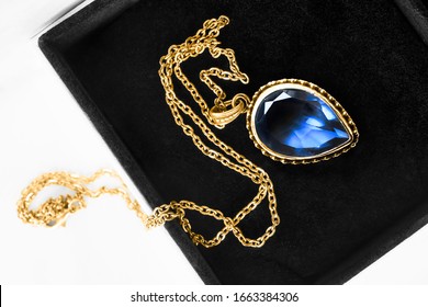 Gold Necklace With Large Blue Crystal Pendant In Jewel Box Closeup