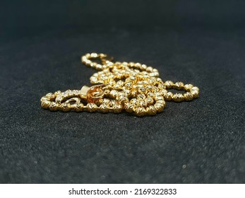 Gold Necklace On Black Background. Flat Lay. Gold Jewelry