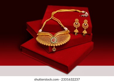 gold necklace with red and black background