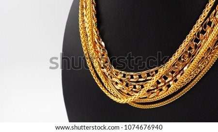 Gold necklaces on necklace display stand.