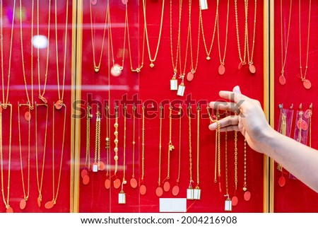 The gold necklaces were hung in the display cabinet.