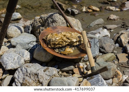 Gold Nugget mining from the River, with a gold pan, and find some big gold nugget.