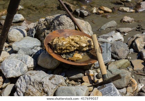 Gold Nugget mining from the River, with a\
gold pan, and find some big gold\
nugget.