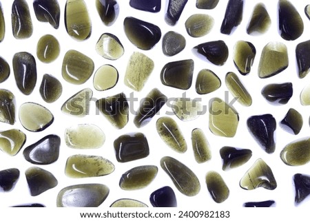 Gold obsidian jewel texture on light surface background. Sparse mineral pebbles creative.