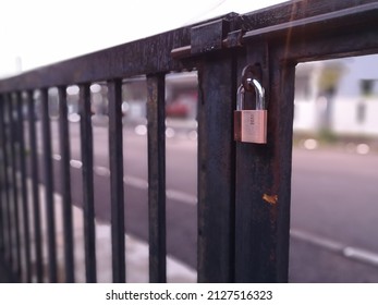 Gold Padlock On Gate With Depth Of Field Camera Effect. This Image May Contain Noise Or Grain Due Of Light Condition.