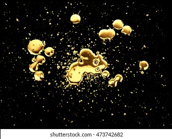 Gold paint splatter isolated on black C