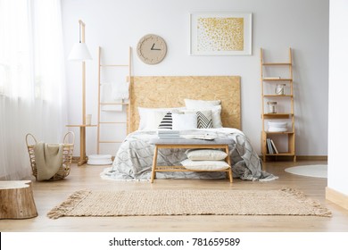 Gold Painting And Handmade Clock In Bohemian Bedroom With King-size Bed And Wooden Furniture