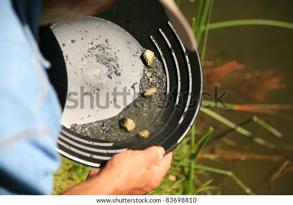 gold panning, man striking it rich\
by finding the mother lode or at least a nugget or\
two