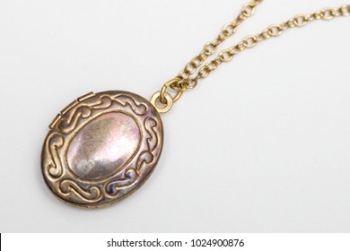 Gold pendant locket necklace on a white background shot up close