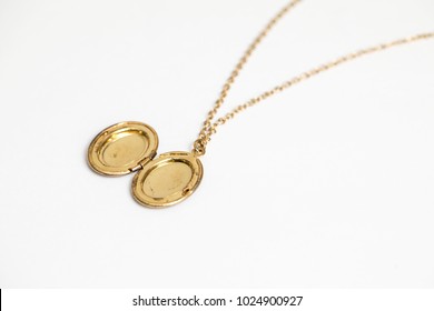 Gold pendant locket necklace on a white background shot up close