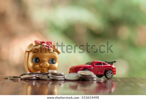 Gold piggy bank with coins and cars concept of money\
saving for car