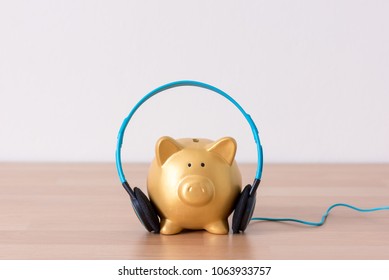 gold piggy bank with head phone listen to music