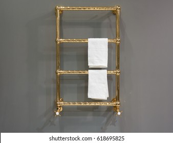 Gold Plated Heated Towel Rail Mounted On The Wall Of The Bathroom