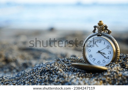 a gold pocket watch on beach sand, symbolizing the eternal beauty of nature and time. Tides of time