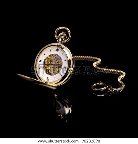 Gold pocket watch on a black background