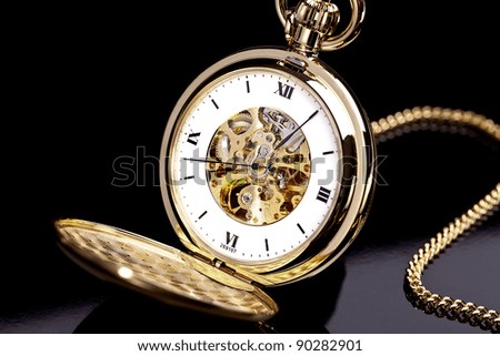 Gold pocket watch on a black background