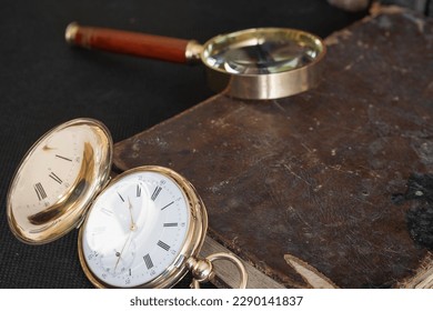 Gold pocket watch "Pavel Bure" on a gold pendant. Royal Russia. pocket watch on a dark background with books. Image of an antique gold pocket watch on an old antique book.