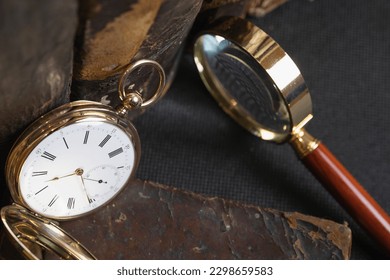 Gold pocket watch "Pavel Bure" on a gold pendant. Royal Russia. pocket watch on a dark background with books. Image of an antique gold pocket watch on an old antique book.