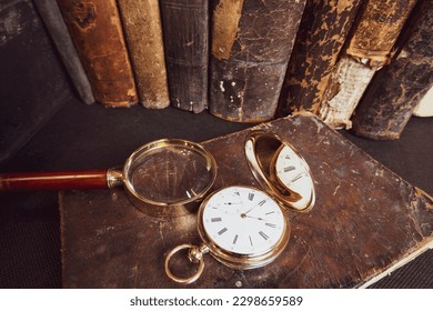 Gold pocket watch "Pavel Bure" on a gold pendant. Royal Russia. pocket watch on a dark background with books. Image of an antique gold pocket watch on an old antique book.