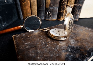 Gold pocket watch "Pavel Bure" on a gold pendant. Royal Russia. pocket watch on a dark background with books. Image of an antique gold pocket watch on an old antique book.