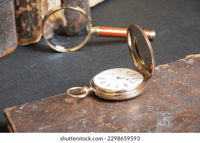 Gold pocket watch "Pavel Bure" on a gold pendant. Royal Russia. pocket watch on a dark background with books. Image of an antique gold pocket watch on an old antique book. - Powered by Shutterstock - Get 15% off with code: PIKWIZARD15