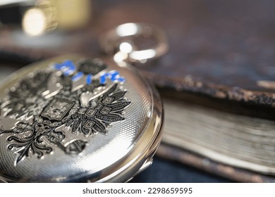 Gold pocket watch "Pavel Bure" on a gold pendant. Royal Russia. pocket watch on a dark background with books. Image of an antique gold pocket watch on an old antique book.