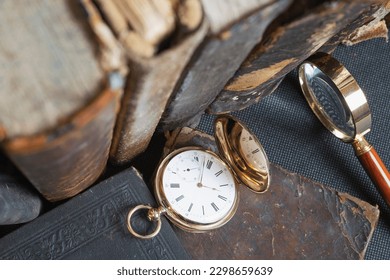 Gold pocket watch "Pavel Bure" on a gold pendant. Royal Russia. pocket watch on a dark background with books. Image of an antique gold pocket watch on an old antique book.