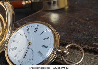 Gold pocket watch "Pavel Bure" on a gold pendant. Royal Russia. pocket watch on a dark background with books. Image of an antique gold pocket watch on an old antique book. - Powered by Shutterstock - Get 15% off with code: PIKWIZARD15