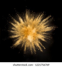 Gold Powder Explosion On Black Background. Freeze Motion.