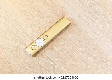 Gold Presentation Remote Control With Arrow Slide Changing Buttons, Object Laying On A Wooden Table, Closeup, Top View, Nobody. Lecture, Talk Or Seminar, Conference, Course Abstract Concept, No People