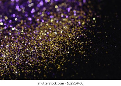 Gold And Purple Glitter On Black Background With Selective Focus